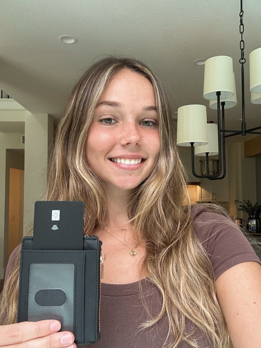 Customer holding up the Vantamo tracker card box at home