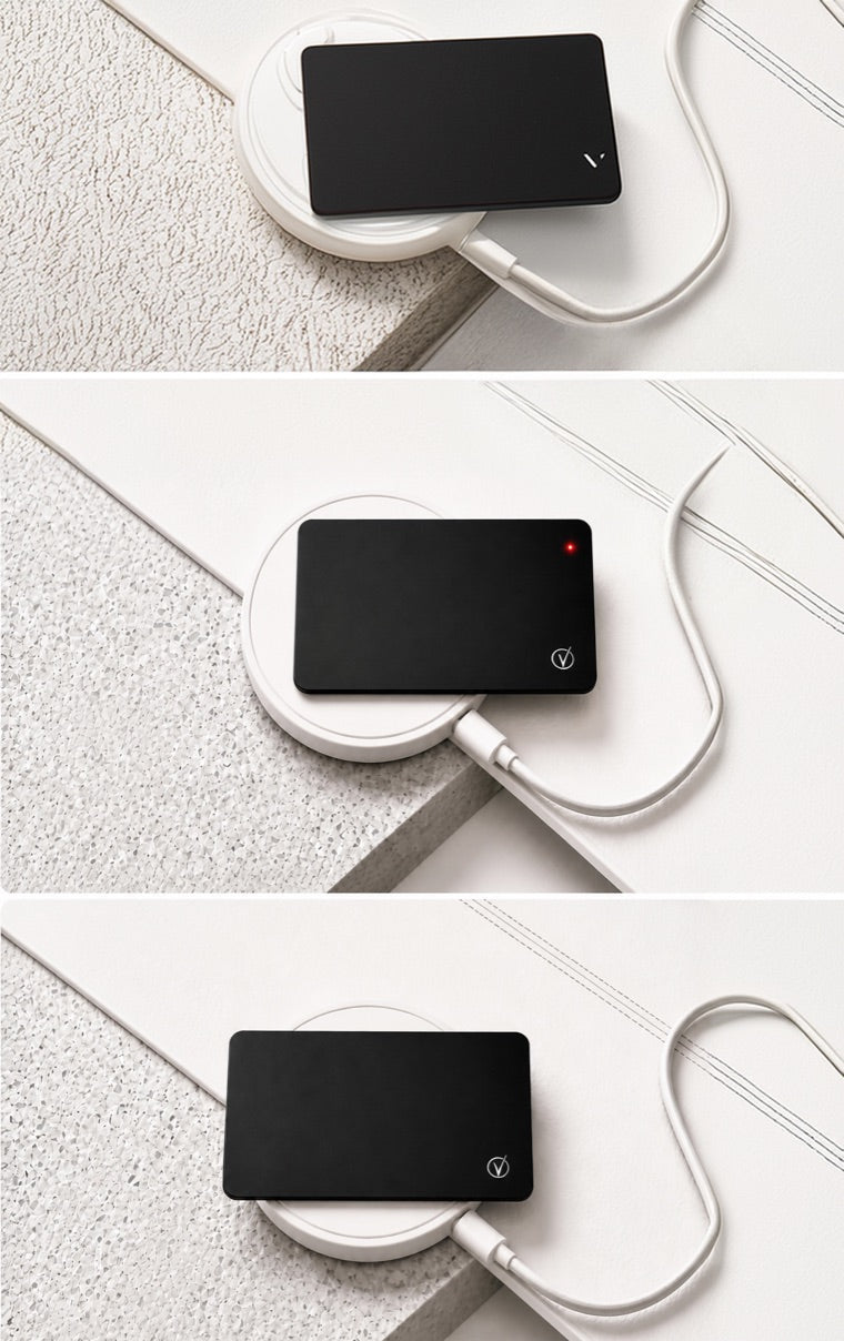 Vantamo tracker card charging on a white wireless charging pad